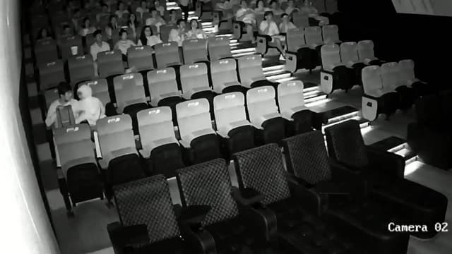 A couple having sex in front of everyone in a cinema hall